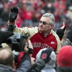 Jim Tressel former Ohio State University head coach celebrating victory after winning won football game post-game cameras waving smiling NCAA college ball ballgame scandal ineligible players